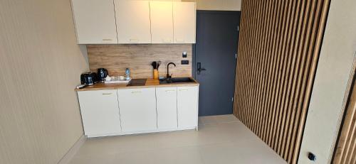 a kitchen with white cabinets and a counter top at Siedmiu Króli Rooms&SPA in Bukowina Tatrzańska