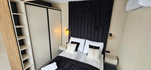 a bedroom with a bed with a black headboard and pillows at Siedmiu Króli Rooms&SPA in Bukowina Tatrzańska