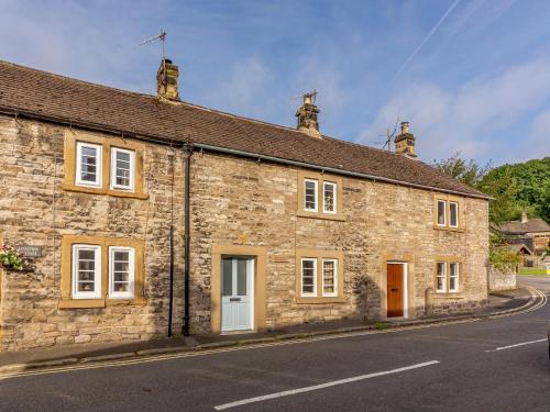 an old stone building on the side of a road at Whibberley Cottage in Ashford