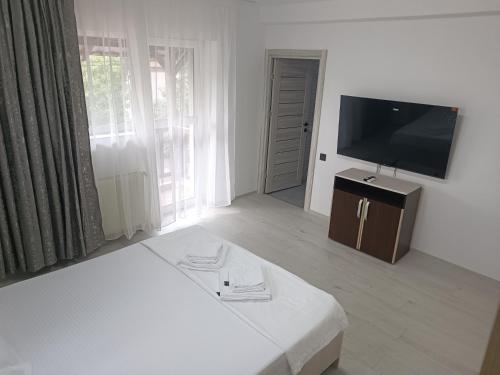a living room with a television and a white table at Max Night Dreams in Bucharest