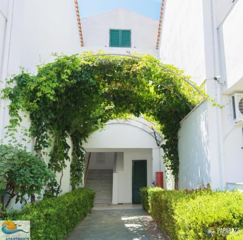 an entrance to a building with an arch with ivy at Chandris Apartments in Kavos