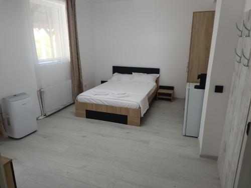 a bedroom with a bed in a white room at Max Night Dreams in Bucharest