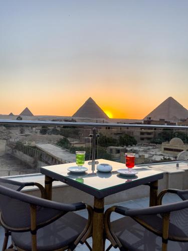 a table and chairs with a view of the pyramids at AKHNATON Pyramids View Hotel With Rooftop Access & free airport pickup in Cairo