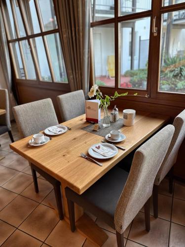 un tavolo in legno con sedie e un computer portatile. di Landhotel Schellenberg a Überlingen