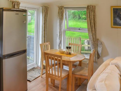 a kitchen and dining room with a table and a refrigerator at Blackberry Lodge in Ripon