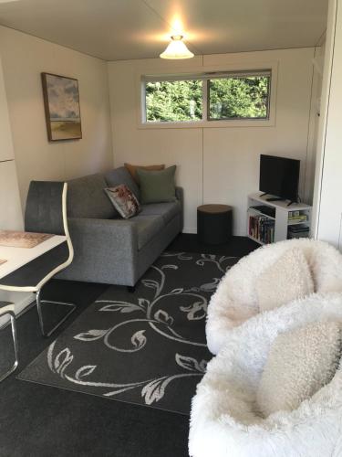 a living room with a couch and a chair at Brookside Country Escape 40 minutes to CHC Airport in Leeston