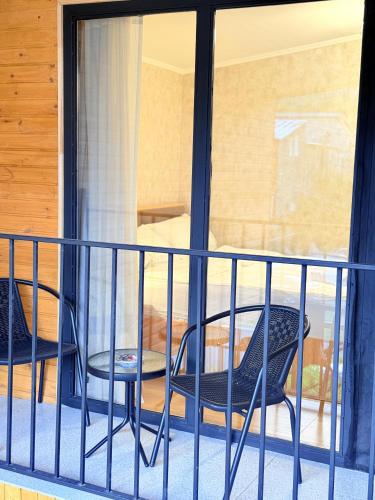 two chairs and a table on a balcony at Four Rooms in Lagodekhi