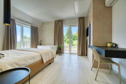 a bedroom with a bed and a desk and a tub at Villa One in Jastrebarsko