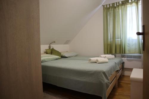 a bedroom with two twin beds and a window at Kuća za odmor Tina in Gladovec Pokupski