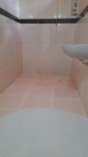 a bathroom with a sink and a white tiled floor at Hostel da Lua in Barreirinhas