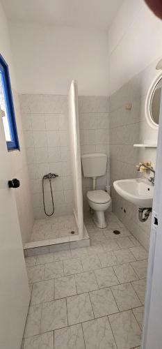 a bathroom with a shower and a toilet and a sink at Pleasure Black Beach Perissa Santorini in Perissa