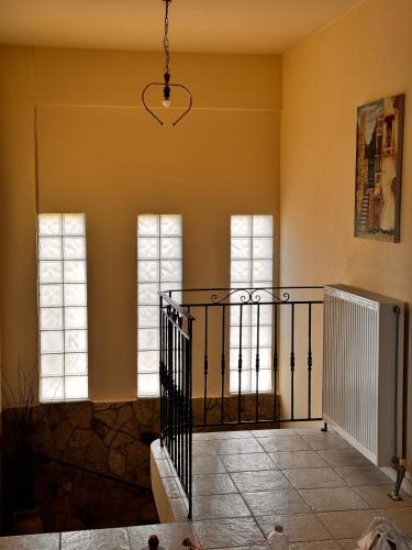 a room with three windows and a staircase at Villa Gaia Navarino in Korifásion