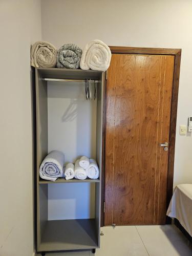 a towel rack with towels and a wooden door at Marmen Apart-Dpto en CDE in Ciudad del Este