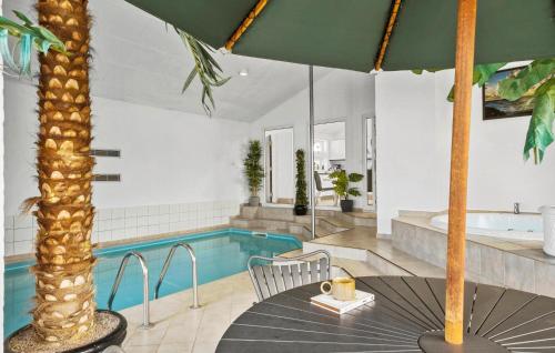 a house with a pool and a table and chairs at Stunning Home In Blokhus With Sauna in Blokhus