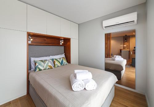 a bedroom with a bed with towels on it at Seagull Lodge incl Parking by Home Sweet Home Aveiro in Aveiro