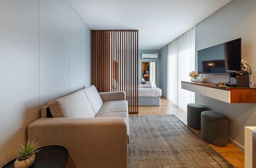 a living room with a couch and a bedroom at Seagull Lodge incl Parking by Home Sweet Home Aveiro in Aveiro