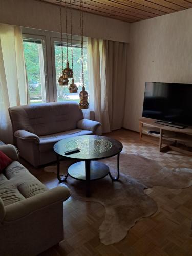 a living room with a couch and a table at Aalto A - A whole house with 5 bedrooms and a woodburning sauna in Oulu