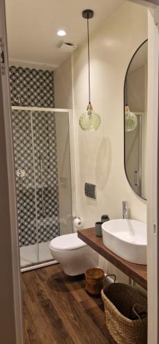 a bathroom with a toilet and a sink and a mirror at Casa Graziella in Capo dʼOrlando