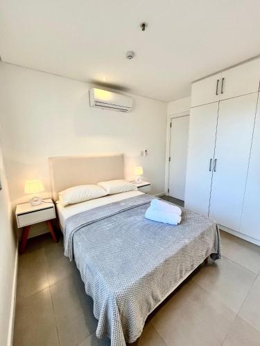 a bedroom with a bed and two tables and cabinets at Edificio Ventura Carmelitas in Asuncion