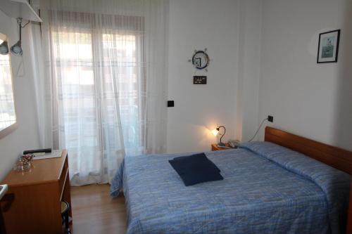 a bedroom with a bed and a desk and a window at Hotel Marea in Grado