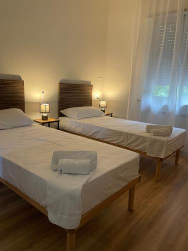 two beds in a hotel room with towels on them at Affittacamere LICEN in Trieste