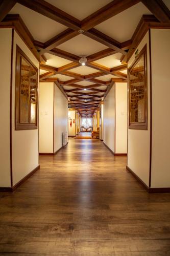 an empty hallway in a building with wood floors and ceilings at Hotel Ritta Höppner in Gramado