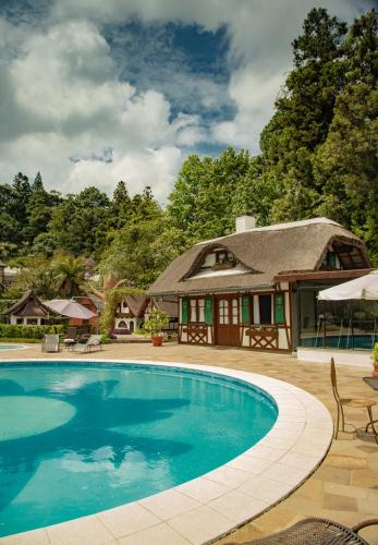 a swimming pool in front of a house at Hotel Ritta Höppner in Gramado