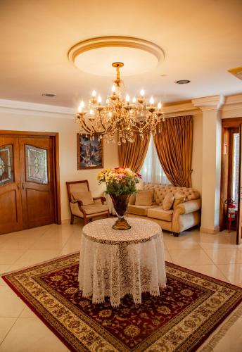 a living room with a table with a vase of flowers at Hotel Ritta Höppner in Gramado