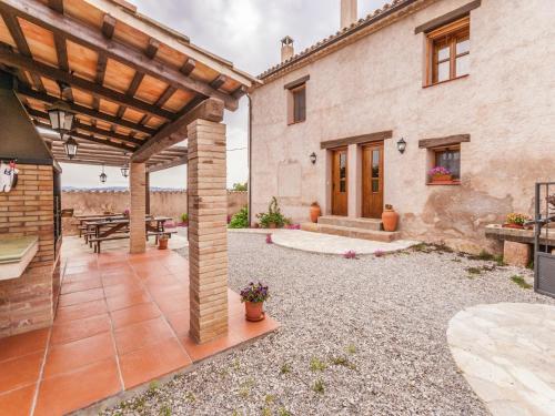 an outdoor patio with a wooden pergola at 17th century farmhouse in Bages near Montserrat in Castellfullit del Boix