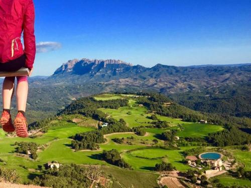 a person standing on top of a mountain overlooking a golf course at 17th century farmhouse in Bages near Montserrat in Castellfullit del Boix