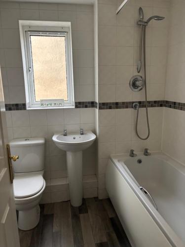Un baño con inodoro, lavabo y bañera. en Cornflower Cottage, 