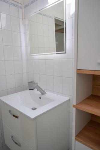 a bathroom with a white sink and a mirror at Le jungle, hyper centre, balcon et terrasse in Tarbes