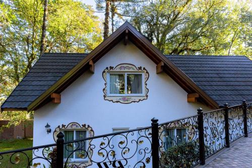 a small white house with a black fence at Hotel Ritta Höppner in Gramado
