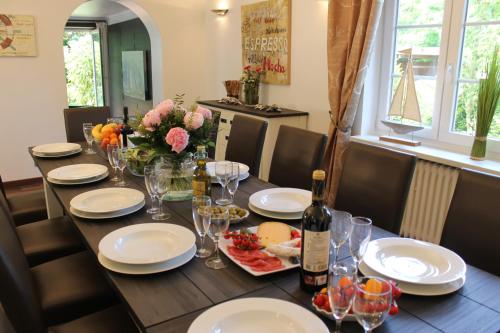 una mesa de comedor con una botella de vino y copas en Ferienhaus Nadja en Westerland