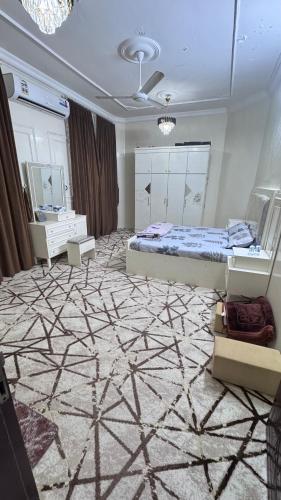 a bedroom with a king sized bed and a mirror at جوهرة الاشخرة in Al Ashkharah