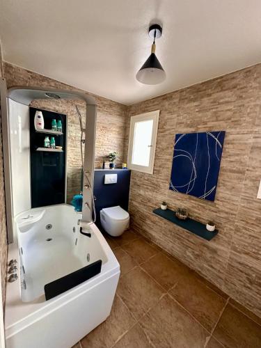 a bathroom with a white tub and a toilet at Villa Naïm Esterel in Saint-Raphaël