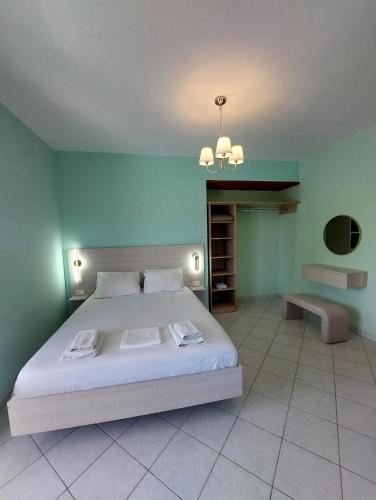 a bedroom with a large white bed and green walls at Xi View Apartments in Lixouri