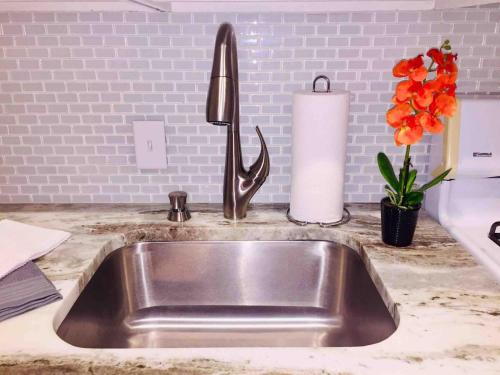a kitchen sink with a roll of paper towels and flowers at Witte Wonderland - Separate Garage Apartment!! in Kyle