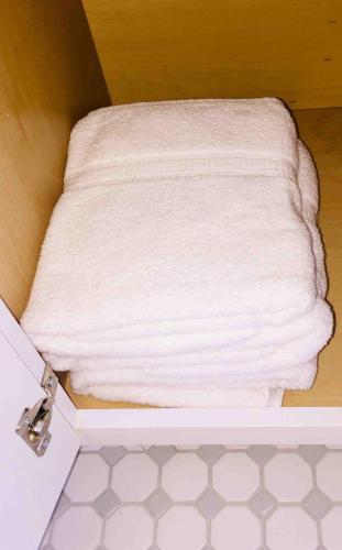 a white towel sitting on top of a bathroom floor at Witte Wonderland - Separate Garage Apartment!! in Kyle
