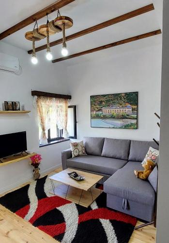 a living room with a couch and a table at Sweet Home Aria in Çorovodë