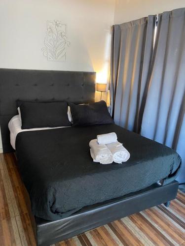 a bedroom with a black bed with two towels on it at Ciervo de Oro in Villa Carlos Paz