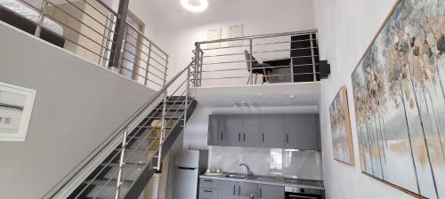 a kitchen with a staircase with a dog in a cage at Modern House Close to the Sea Asprovalta in Asprovalta