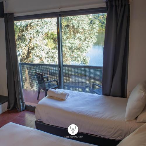 a bedroom with two beds and a balcony with a view at Ciervo de Oro in Villa Carlos Paz