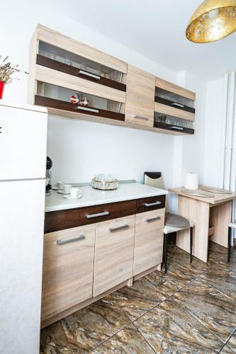 a kitchen with wooden cabinets and a white refrigerator at Apartament Benicarlo1 in Brad