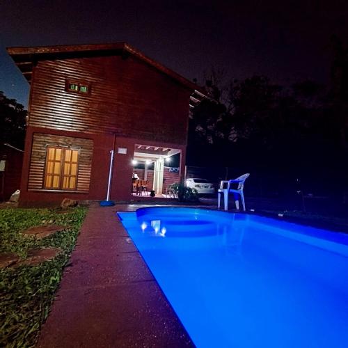 ein Swimmingpool vor einem Haus bei Nacht in der Unterkunft Cabañas Flores de Lapacho Iguazu in Puerto Iguazú