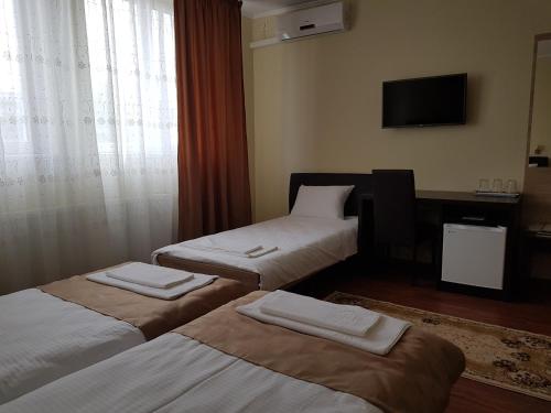 a hotel room with two beds and a television at Hotel New in Baia Mare