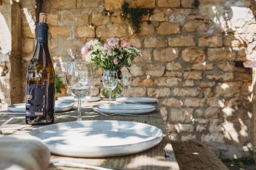 a table with a bottle of wine and plates and glasses at The Cow Byre in Dursley