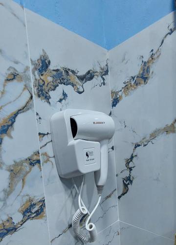 a hair dryer on a wall in a bathroom at Sweet Home Aria in Çorovodë