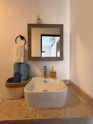 a bathroom with a white sink and a mirror at Puerta al Sol in Acapulco