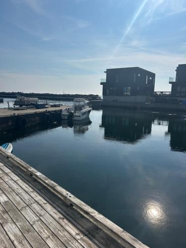 a boat is docked in the water near a building at Flott Leilighet, 1 etasje med nydelig sjøutsikt in Karmøy